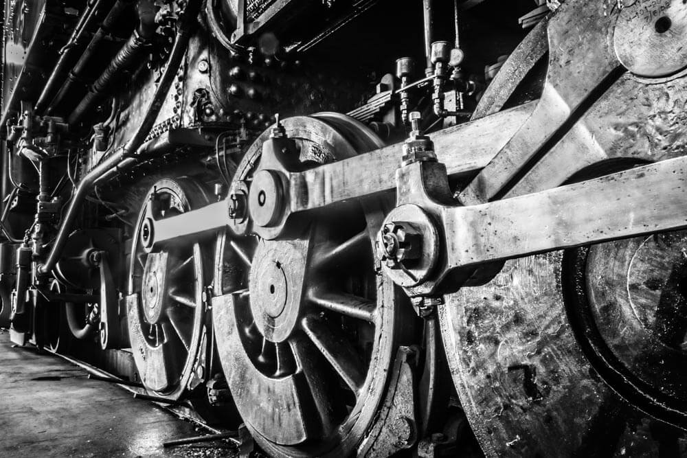 Close up black and white image of train wheels.