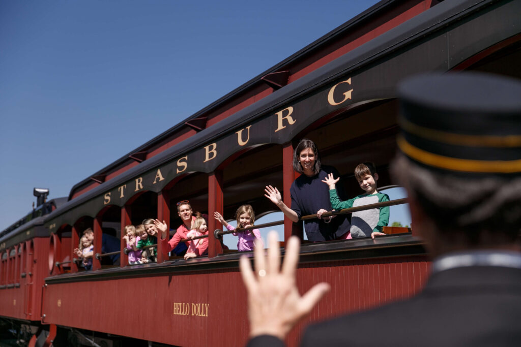 Kids waiving while riding Hello Dolly