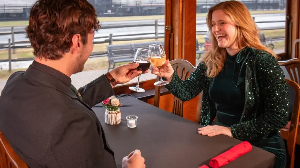 The Elegant Express 2 A couple clinking wine glasses over a suave table setting.